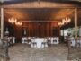 an outdoor dining area with tables and chandeliers