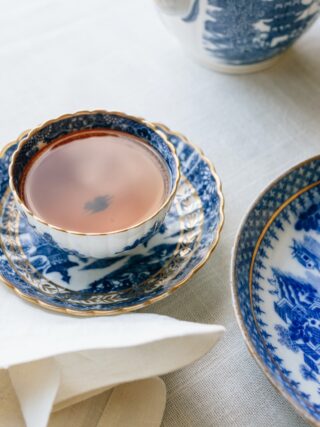 cup filled with brown liquid near plate - Porzelanhochzeit Geschenk