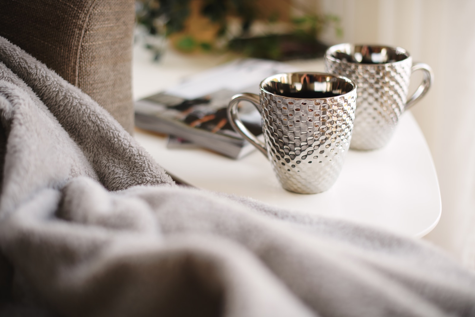 two silver mugs on white side table - Geschenke zur Silberhochzeit