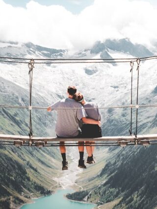 wochenendtrip zu zweit - minimoon - man and woman sitting on hanging bridge at daytime